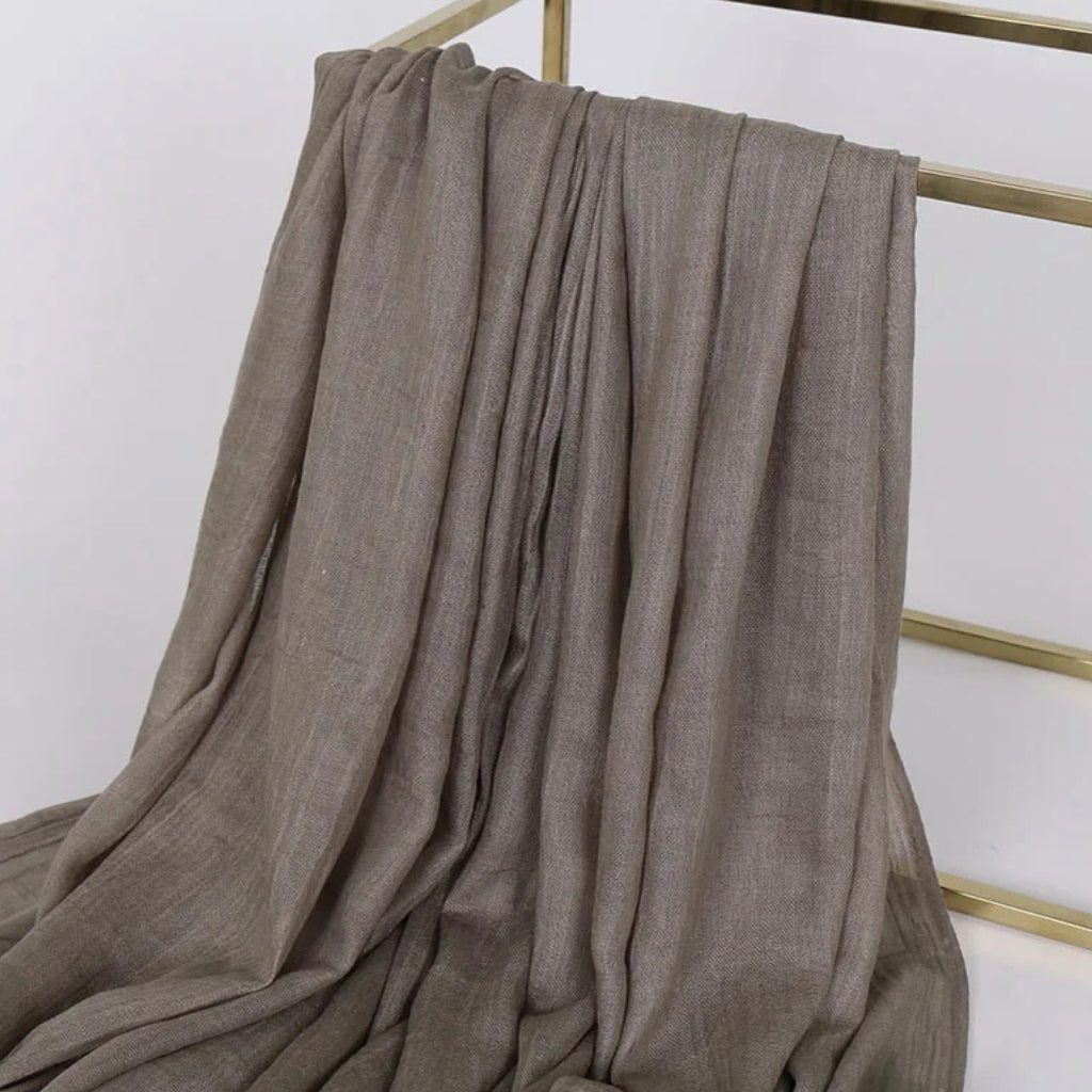Chèche Coton Uni tissu drapé sur support - Gris Olive - Beige Clair - Jaune Moutarde - Pêche Douce - Marron Terre - Bleu Marine - Terracotta - Bleu Pétrole - Violet Foncé - Bleu Ciel - Terre Cuite - Bordeaux - Gris Clair - Vert Foncé - Corail Doux - Rose Pâle - Blanc Crème - Orange Vif - Corail Éclatant - Vert Menthe