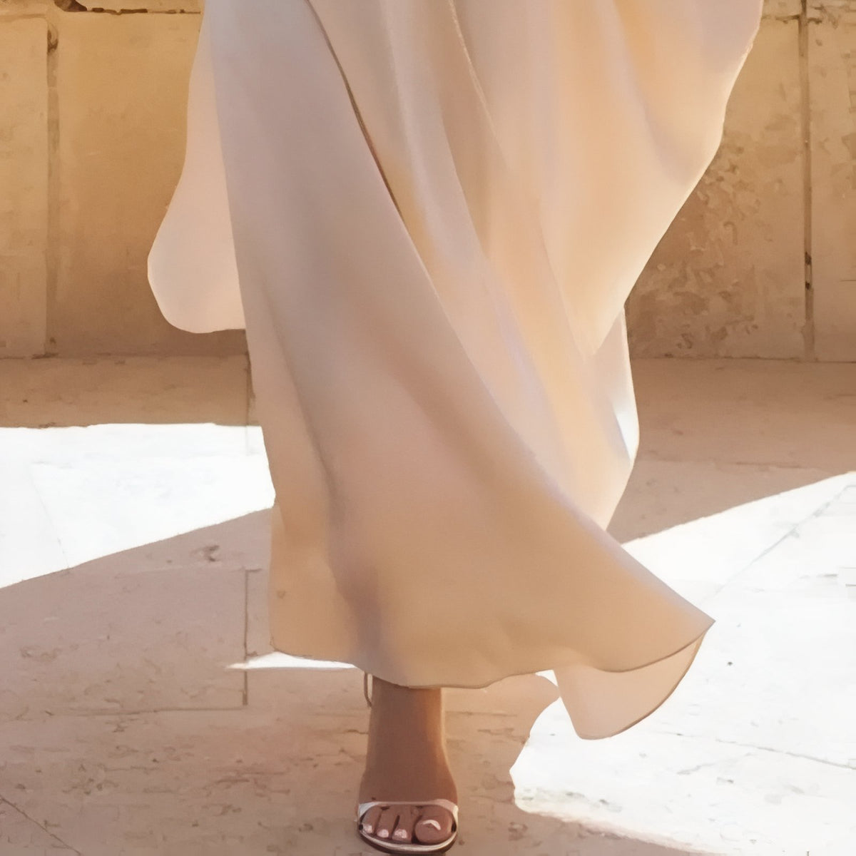 Robe de Plage Asymétrique Blanche à Épaule Dénudée portée en mouvement - Beige